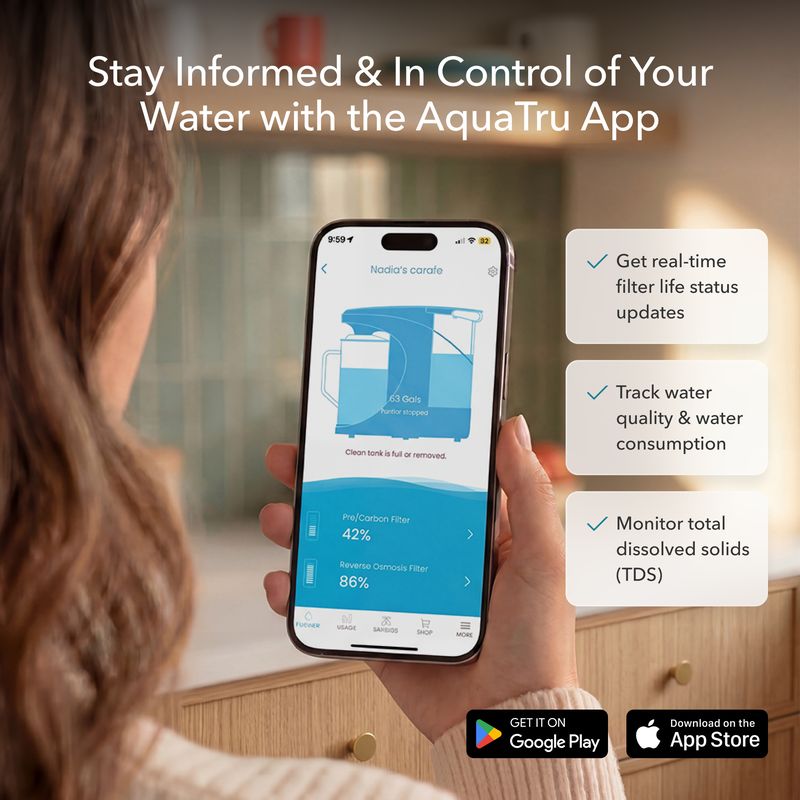 A person holding a smartphone displaying the AquaTru app, showing water filter status and quality metrics.