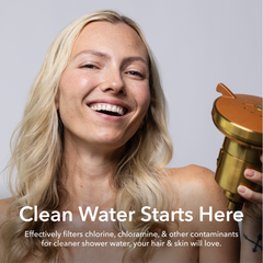 Woman holding a golden color AquaTru Showerhead.
