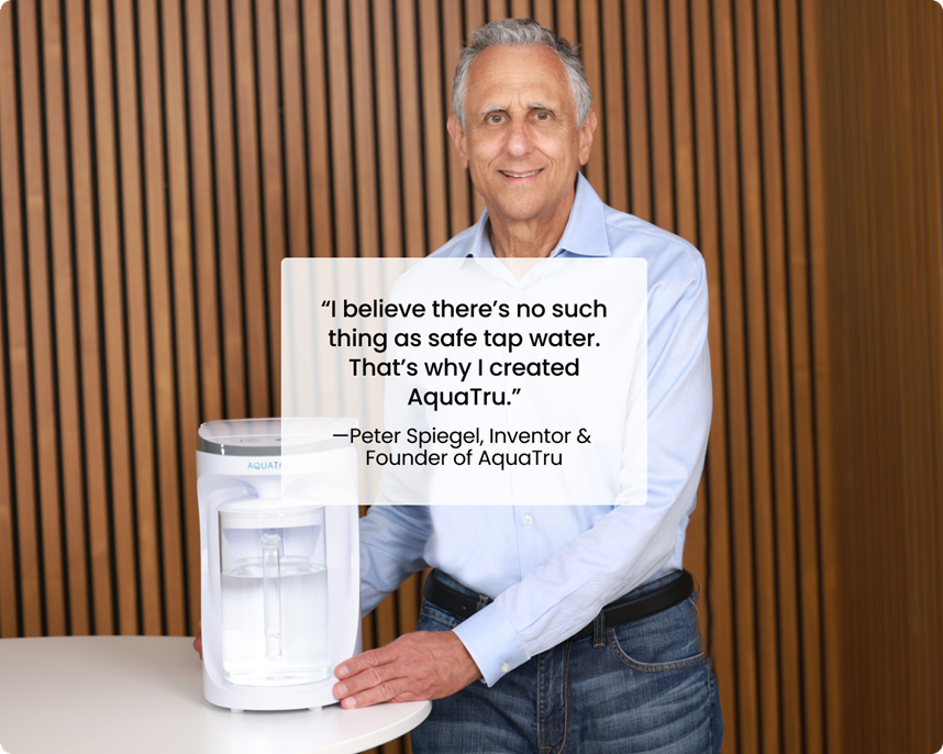 A man stands beside a water purification system, sharing his belief in the importance of safe drinking water.