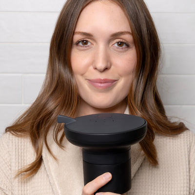 Woman holding AquaTru® Showerhead